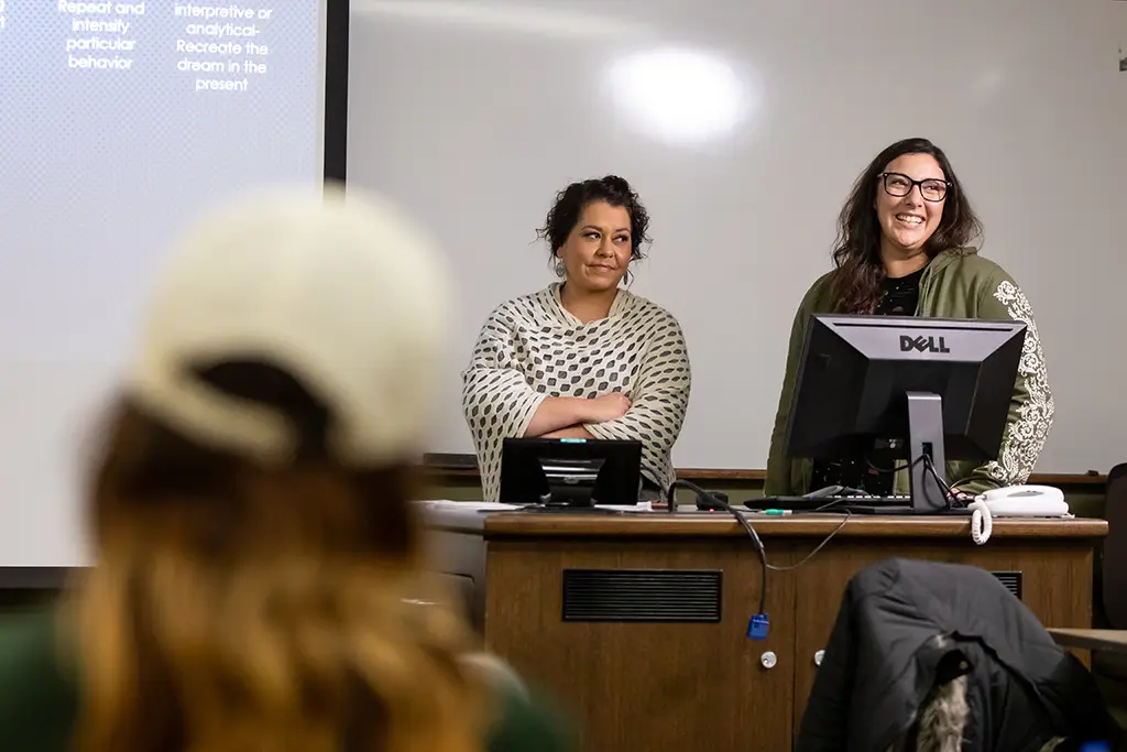 two students presenting in front of screen