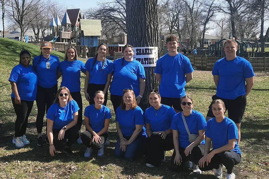 group of students in blue shirts outside