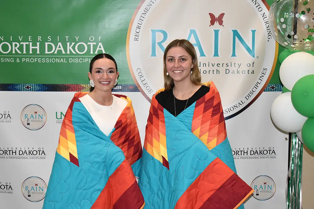 two people with blankets around shoulders