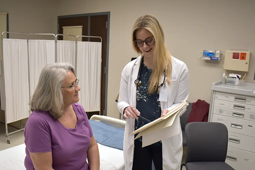 nurse with patient in exam room