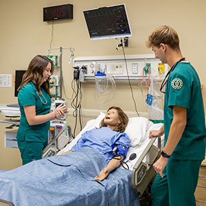 Two nursing students complete a clinical exercise in the Simulation Center.