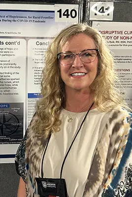 Stephanie Orth stands in front of a poster of her research