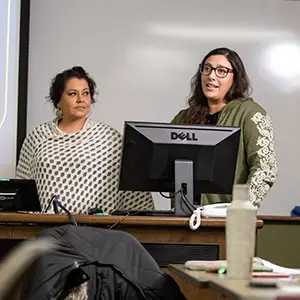 two students presenting by computer